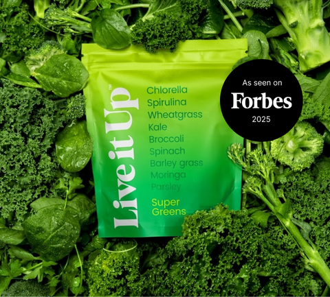 A pouch of Live it Up Supergreens set against a backdrop of lush green whole food ingredients