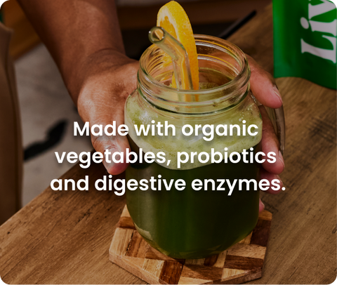 A mason jar with a clear straw and a lemon slice on the rim, super greens are inside; the overlaid text reads: Made with organic vegetables, probiotics, and digestive enzymes.